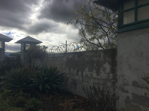 Forbidding wall with towers and razor wire